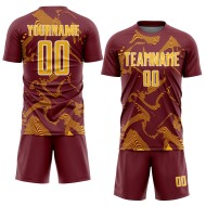 Maillot de football personnalisé à sublimation dorée et blanche bordeaux avec lignes courbes sportives Maillot de football personnalisé à sublimation dorée et blanche bordeaux avec lignes courbes sportives